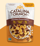 A package of Catalina Crunch protein cereal in Chocolate Peanut Butter flavor. The packaging is predominantly white with images of the cereal pieces and the brand's logo, and it states that the product contains 'No Artificial Flavors or Sweeteners'.