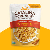 A package of Catalina Crunch protein cereal in Cinnamon Toast flavor. The front of the package shows the cereal with milk and has labels such as 'No Artificial Flavors or Sweeteners', '11g Protein', and '0g Sugar'.