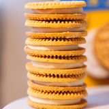 Stack of sandwich cookies with cream filling on a blurred background