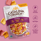 Catalina Crunch Protein Cereal package on a pink background with cereal pieces around.