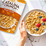 Catalina Crunch Maple Waffle cereal package and bowl with cereal and berries on a marble surface