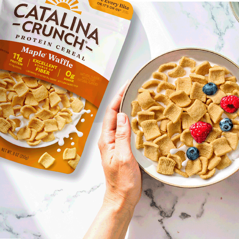 Catalina Crunch Maple Waffle cereal package and bowl with cereal and berries on a marble surface