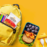 Yellow backpack with snacks and a lunchbox on a yellow background