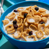 Blue bowl of cereal with milk and raisins on a blue tray