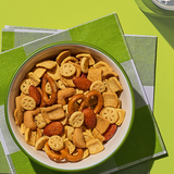 Assorted snack mix in a bowl on a green checkered tablecloth